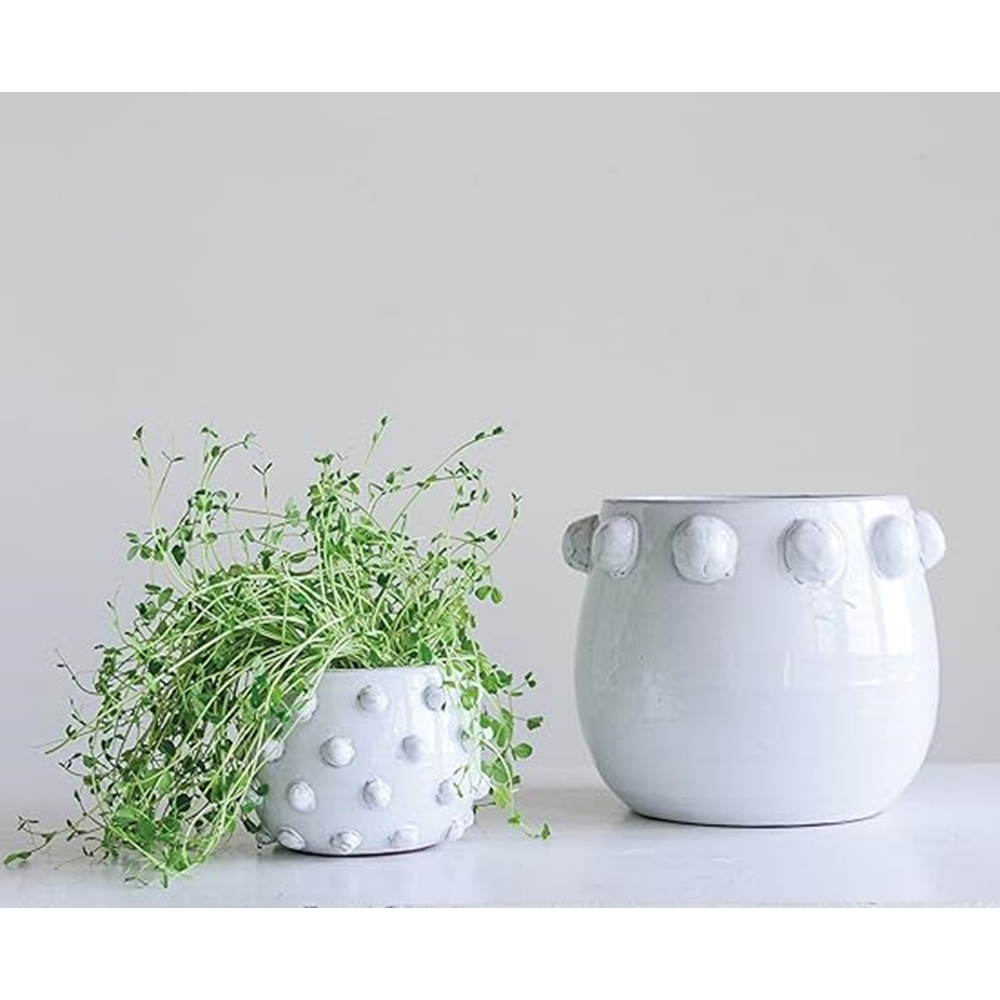 Two white ceramic planters with decorative knobs on a light gray background